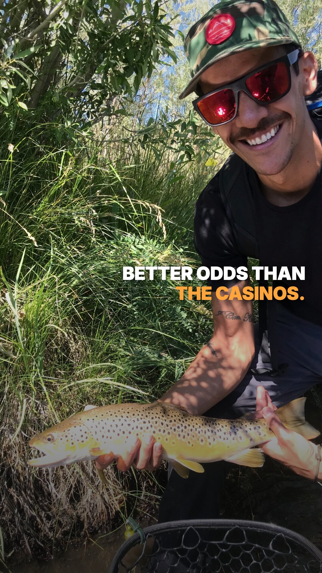 Ad: grinning angler with a brown trout, hook better odds than the casinos (vertical version)