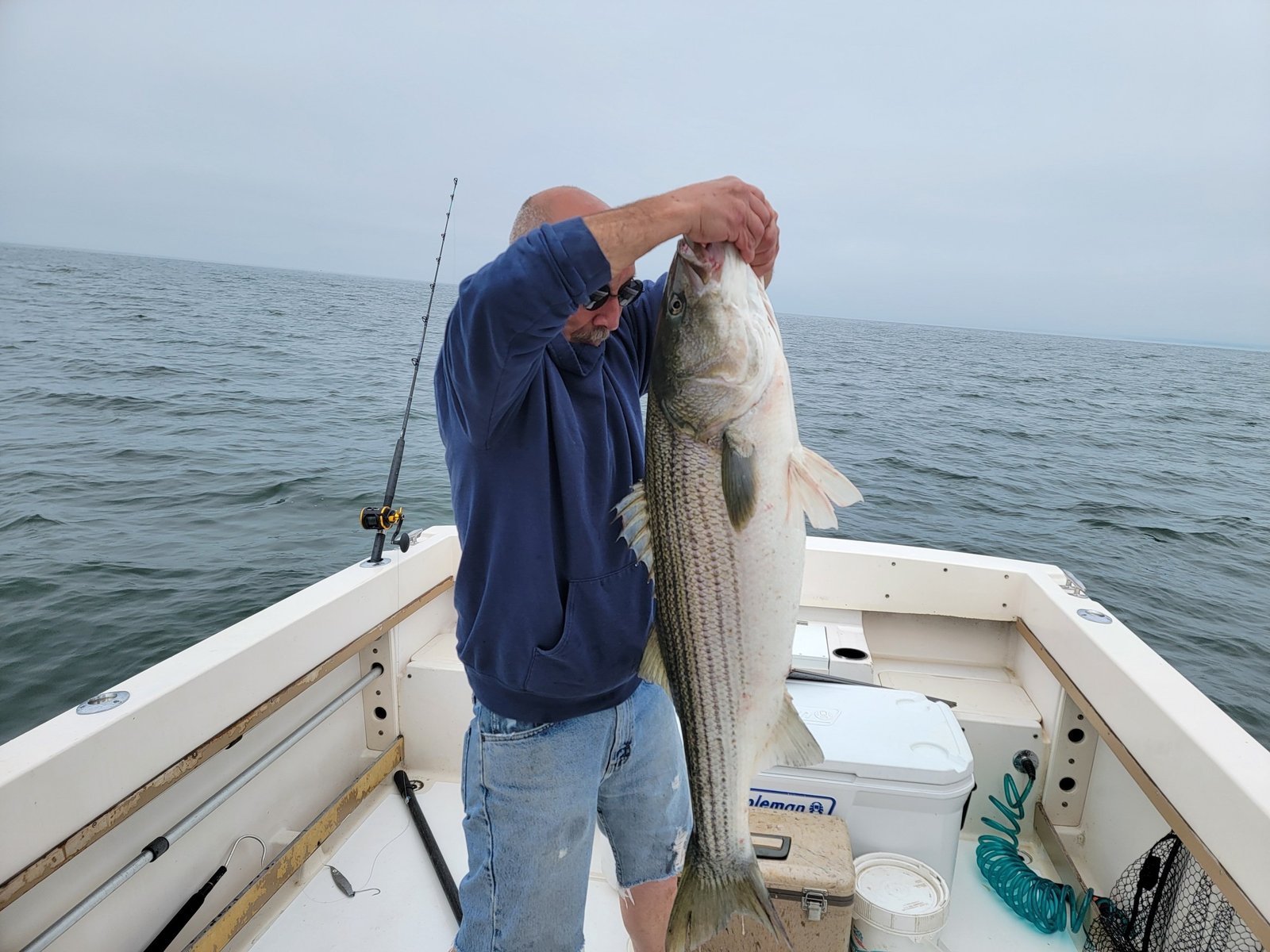 A guide working with a client on the water, photographed by Bad Habit Fishing Charters in CT