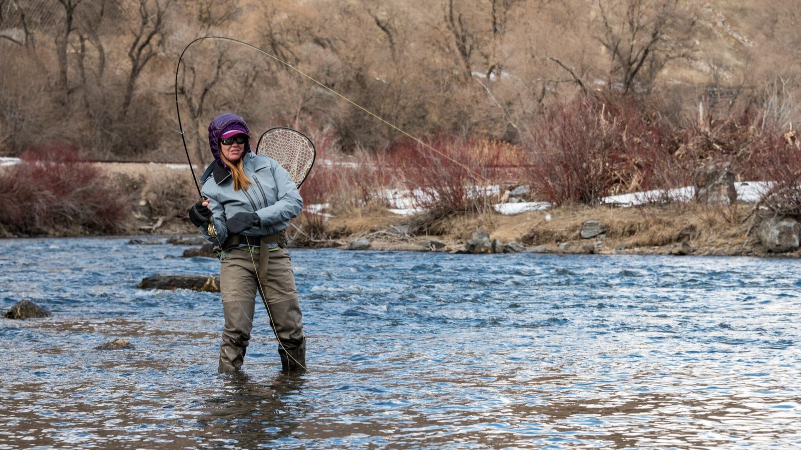 A guide working with a client on the water, photographed by Beehive Fishing Company in UT