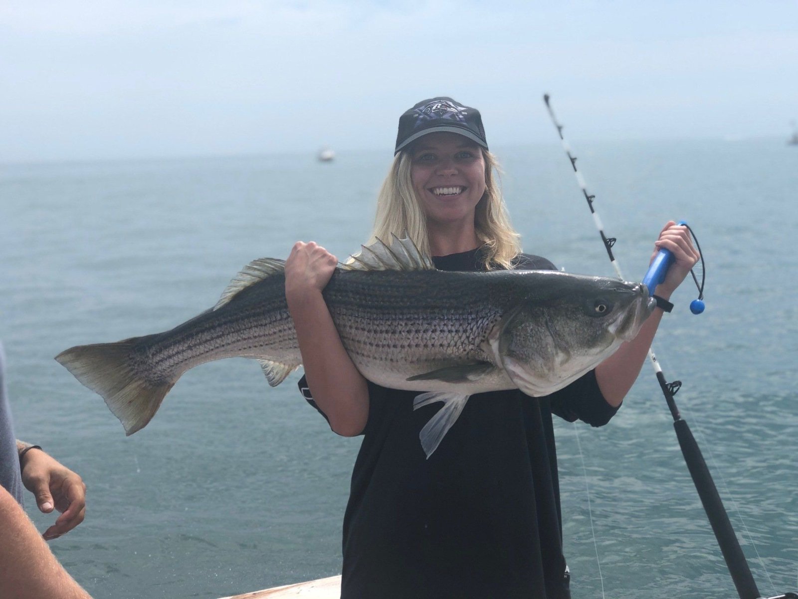A guide working with a client on the water, photographed by Boston Fishing in MA