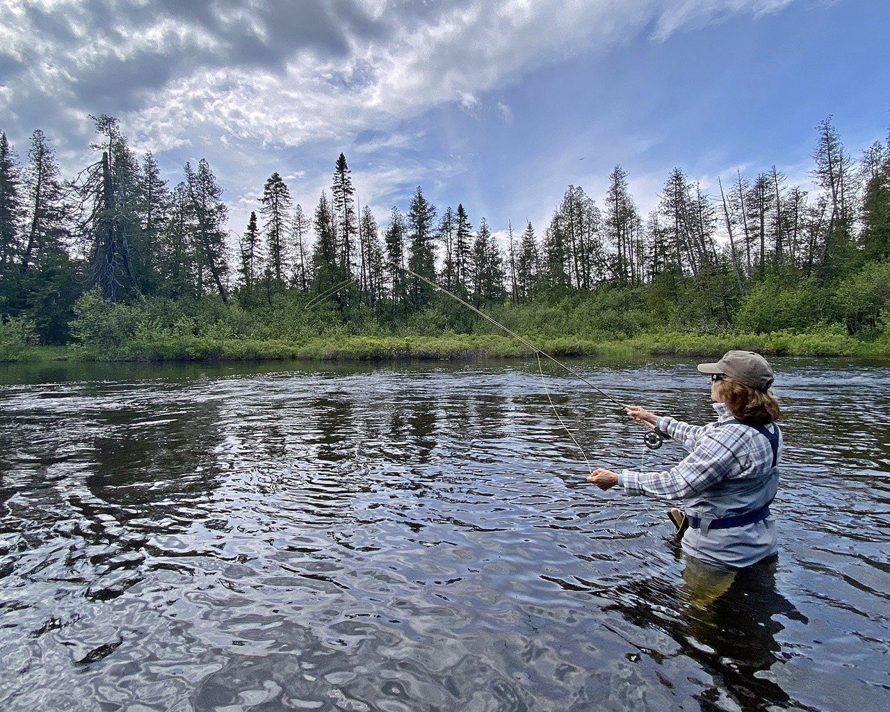 A guide working with a client on the water, photographed by Chandler Lake Camps and Lodge in ME