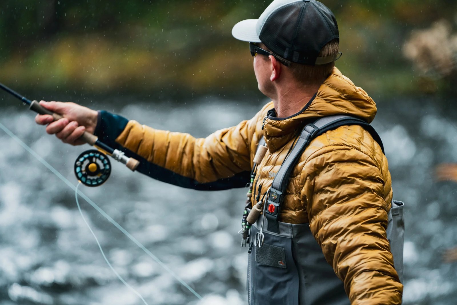An angler in a gold jacket locked into a cast on winter water