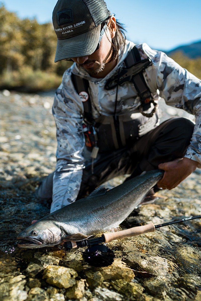 A guide working with a client on the water, photographed by Iliamna River Lodge in AK