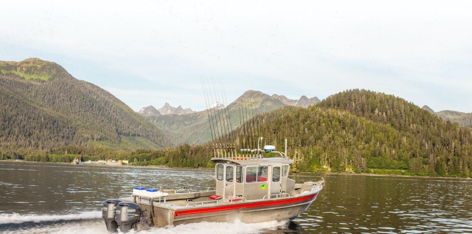 A guide working with a client on the water, photographed by Kain's Fishing Adventures in AK