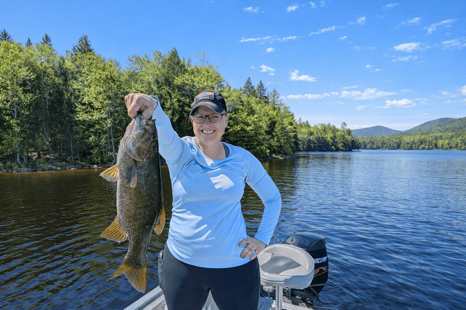 A guide working with a client on the water, photographed by Maine Wilderness Fishing in ME