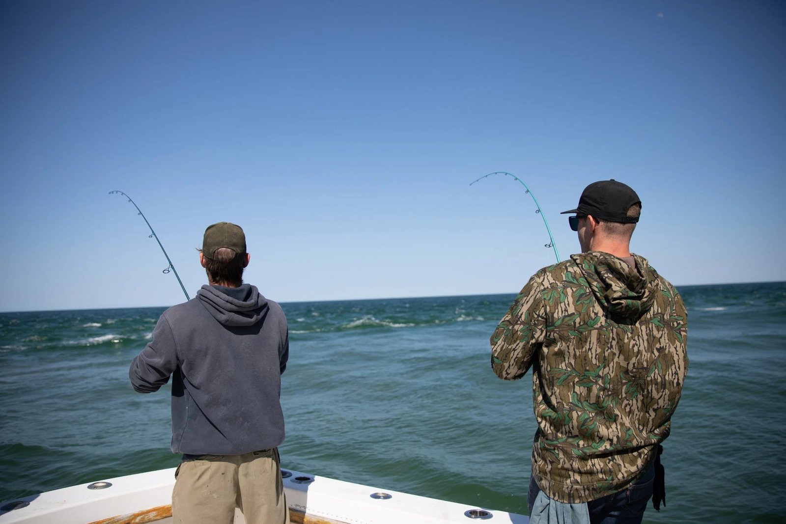 A guide working with a client on the water, photographed by Seabilly Fishing Charters in MA
