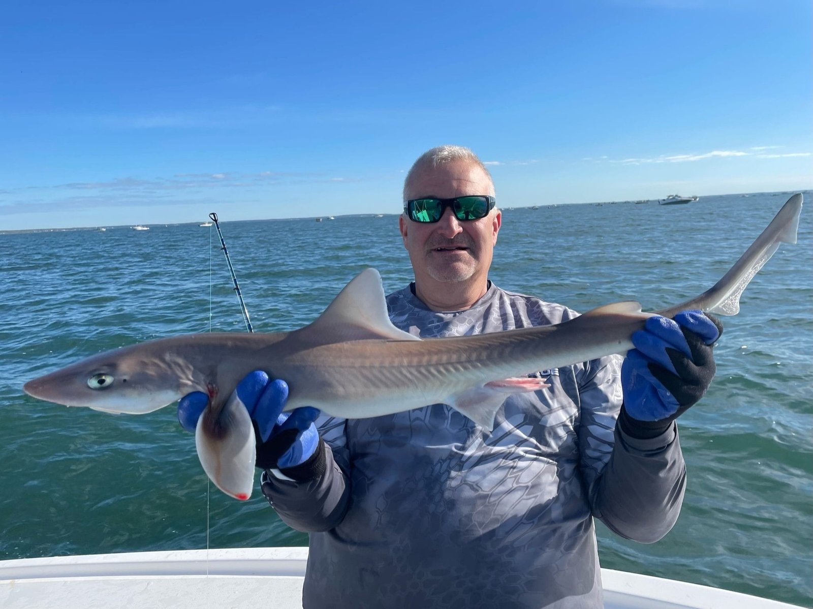 A guide working with a client on the water, photographed by Smokin Reels Fishing Charter in MA