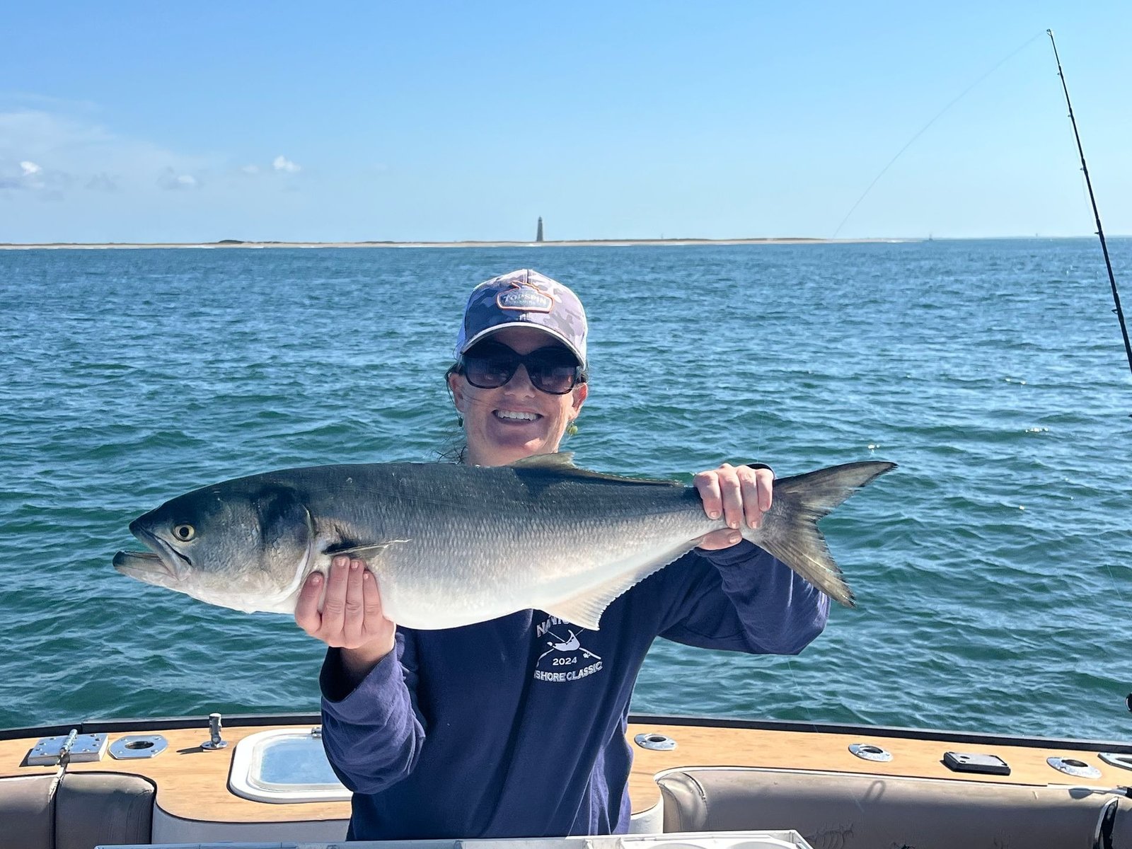 A guide working with a client on the water, photographed by Topspin Fishing Charters in MA