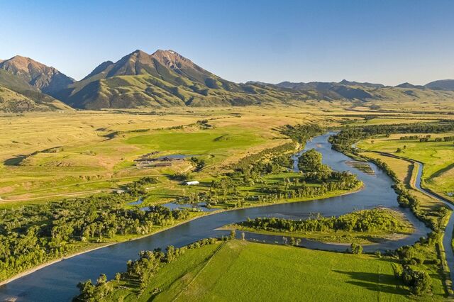 A trout river winding through a green valley, seen from above